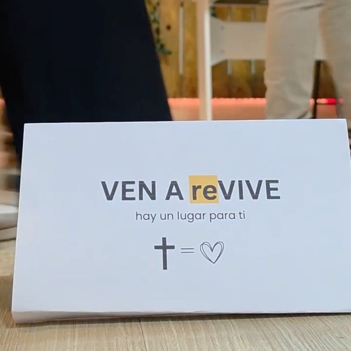 La tarjeta «Ven a reVIVE: hay un lugar para ti» sobre la mesa del salón
